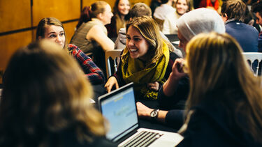 Group of smiling students with laptop