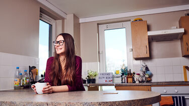 A student sat in their kitchen 