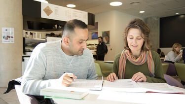 two mature students working in a cafe - image 