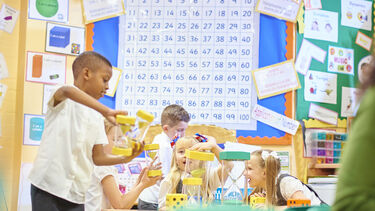 Children playing with hourglasses in a primary school maths lesson