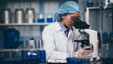 Young scientist working with a microscope in a laboratory. Young scientist doing some research.