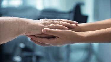 Photo of a young and older person's arms stretched out to lay the older person's arms across the younger arms.