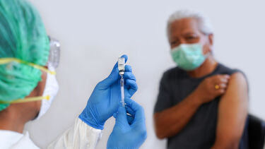 Close-Up Of Doctor Preparing Syringe For Patient - stock photo