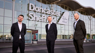 Three representatives from the University of Sheffield, DSA and Peel L&P stood in front of DSA's terminal building