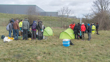 Workshop participants working around tents in a field
