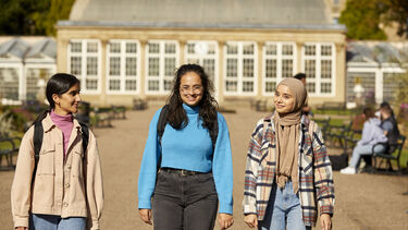 Three students walking in botanical gardens