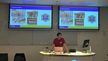 Photograph of Aiman giving a talk on Student Experience