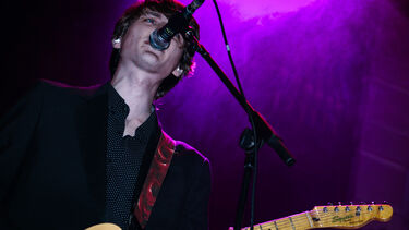 Man playing guitar and singing into mic