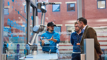 Student with Robot Arm explaining the machine 