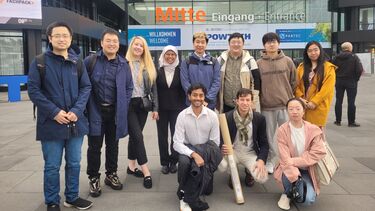 A group smiling outside of a building