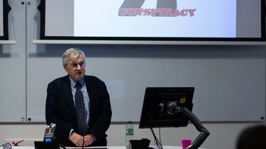 Richard J. Evans in front of screen with text 'conspiracy'
