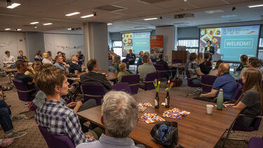 A room full of people listening to a speaker at the front