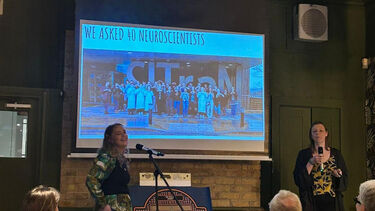 Alicja Olejnik and Dr Naomi Hartopp standing in front of a projector and speaking into microphones