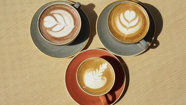 Three coffees with different latte art 