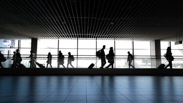 People walking down a long corridor in an airport.