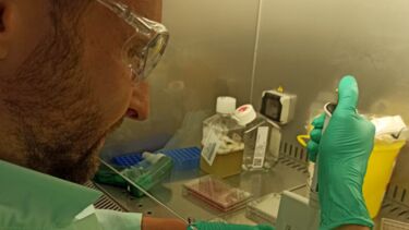 Alex Keeley in lab coat/equipment conducting tests