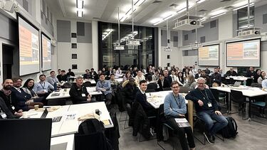 Full room of people listening to a speaker