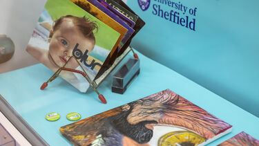 A museum display with a painting of an eye on canvas, a selection of 7" vinyl records in a stand, and badges which say Discover. 