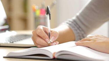 Student writing in a notebook