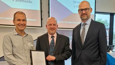 Three men standing together holding a framed certificate