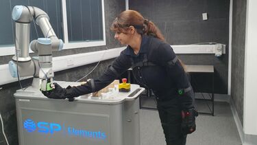 Engineer wearing sensors and communicating with a robotic arm