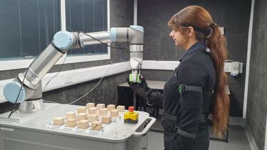 Engineer wearing sensors and communicating with a robotic arm