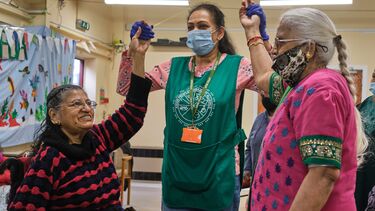 Three women joining hands and smiling