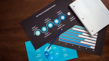 A photograph of a wooden table with infographic resources spread across the table.
