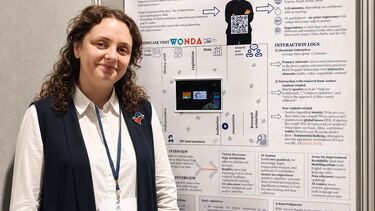Ana K poses in front of a poster 'Immersive Learning Across Borders