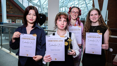 Team of 4 women holding certificates for photo