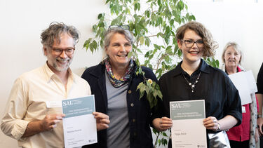 Two students show their certificates with academic