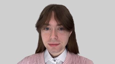 A smiling young man in a pink vest