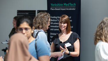 A group of women talking in front of a Yorkshire MedTech promotional banner