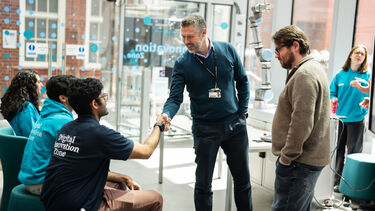 Dave Moss shaking hands with students 