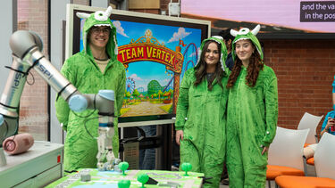 Students in the DIZ in front of a screen with their team name on