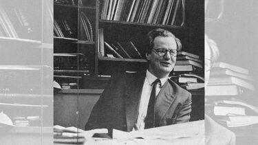 A black and white photo of a man sitting at a desk