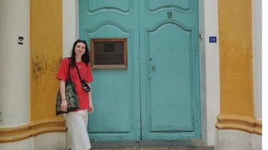 A woman standing in front of a large blue door in India