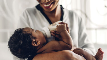 Mother feeding a baby with a bottle.