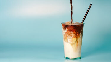 Iced Coffee being poured at The Wave Kitchen in front of blue background
