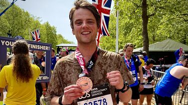 A smiling young man with a race medal