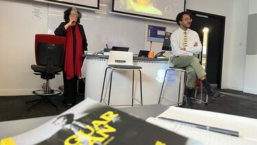 Ida Does and Raoul de jong clearly presenting material for an audience. In the foreground a copy of De Jong's book Jaguarman