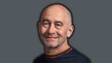 A smiling man on a dark grey background