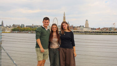 Three students in front of the city scape of Ghent