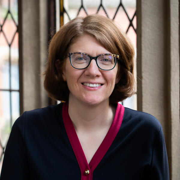 Profile picture of Portrait of a person with short straight brown hair wearing glasses
