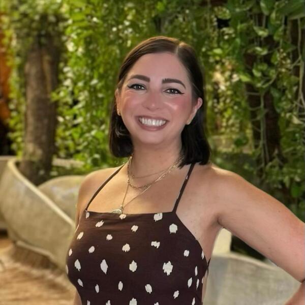 Profile picture of A female stands with her hand on her hip and smiles towards the camera. Behind her are some trees.