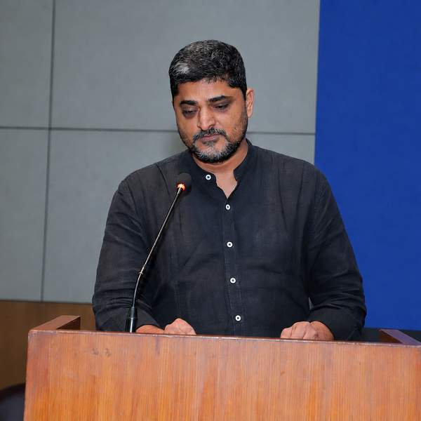 Profile picture of Sandeep R. Singh standing behind a podium