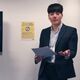 Year in Industry student Andrew Do giving a presentation. He has one a suit and hold a piece of paper. 