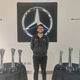 Photo of student Shamoil Khomosi at Mercedes surrounded by trophies