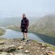 Bradley stood in a mountainous area in front of a river or lake