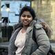 Jahanavachandrika Kotha wearing a grey puffer coat and smiling